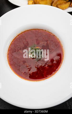 Ukrainische Borschtsuppe mit Sauerrahm und Dill in einer weißen Schüssel, Blick von oben Stockfoto