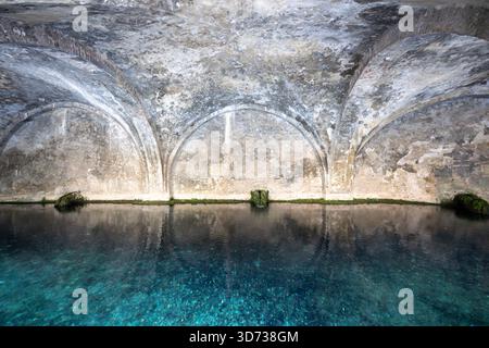 Fontebranda in Siena, ein mittelalterlicher öffentlicher Brunnen, verfügt über gotische Bögen und reflektiert klares Wasser darunter. Die Steinstruktur stammt aus dem 13. Jahrhundert Stockfoto
