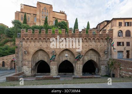 Fontebranda, ein gotischer Brunnen aus dem 13. Jahrhundert in Siena, Italien, verfügt über drei Bögen und Zinnen aus Ziegelsteinen. Historisch bedeutsam für seine Rolle in m Stockfoto
