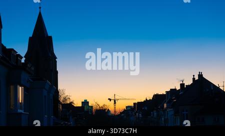 Kran in einer blauen Stunde Sonnenaufgang - Unterstützung Ukraine - Bild für neue Gebäude in Blau und Gelb - Neubeginn nach dem Krieg Stockfoto