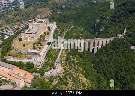 Aus der Vogelperspektive die Rocca Albornoziana, eine Festung aus dem 14. Jahrhundert, und die mittelalterliche Ponte delle Torri-Aquäduktbrücke in Spoleto, Italien. Umgeben von üppigem Grün Stockfoto