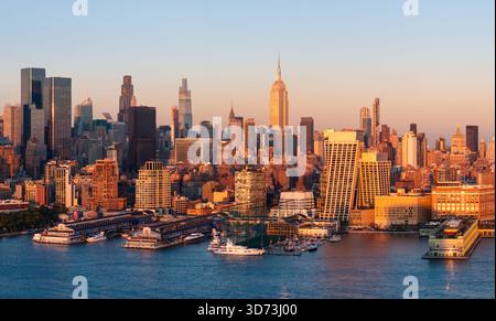 Panoramablick auf die Skyline von Manhattan bei Sonnenuntergang mit Wolkenkratzern in Midtown, Hudson River Uferpromenade und Chelsea Piers. New York City, USA Stockfoto