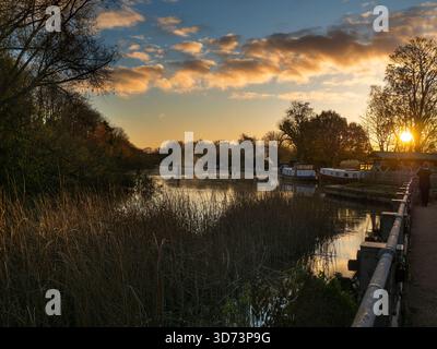Blick vom Fußweg über das Abingdon Weir an der Themse, spektakulärer Wintersonnenaufgang Abingdon-on-Thames behauptet, die älteste Stadt Englands zu sein. Und die Themse fließt durch ihr Herz. In dieser idyllischen Szene sehen wir von den Abingdon Locks aus einen recht schönen Blick auf den Fluss, gerade während die Sonne an einem schönen Wintermorgen aufgeht. So ruhig... Stockfoto