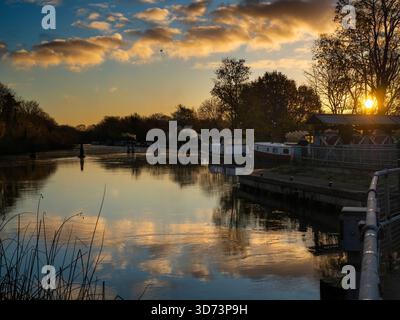 Blick vom Fußweg über das Abingdon Weir an der Themse, spektakulärer Wintersonnenaufgang Abingdon-on-Thames behauptet, die älteste Stadt Englands zu sein. Und die Themse fließt durch ihr Herz. In dieser idyllischen Szene sehen wir von den Abingdon Locks aus einen recht schönen Blick auf den Fluss, gerade während die Sonne an einem schönen Wintermorgen aufgeht. So ruhig... Stockfoto