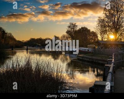 Blick vom Fußweg über das Abingdon Weir an der Themse, spektakulärer Wintersonnenaufgang Abingdon-on-Thames behauptet, die älteste Stadt Englands zu sein. Und die Themse fließt durch ihr Herz. In dieser idyllischen Szene sehen wir von den Abingdon Locks aus einen recht schönen Blick auf den Fluss, gerade während die Sonne an einem schönen Wintermorgen aufgeht. So ruhig... Stockfoto