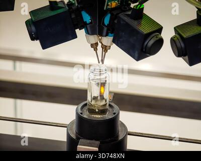 Parfümproduktion. Verschiedene Düfte in Flaschen. Roboterparfüm-Produktionslinie mit automatisierter Duftspende Stockfoto