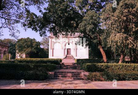Eine breite symmetrische Aufnahme eines historischen Indianerdenkmals mit ornamentalen Bögen, Steintreppen und umgeben von üppigem Grün. Eine ruhige Mischung aus Architektur und Natur. Stockfoto