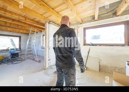 Person, die während der Renovierung in einem Dachgeschoss mit Tageslicht arbeitet Stockfoto