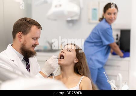 Frau, die ihre Zähne bei einem Zahnarzttermin überprüft Stockfoto