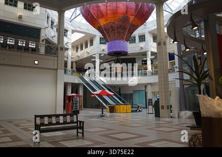 Rolltreppen in der Nähe des leeren Eingangs der Cottonwood Mall in Albuquerque, New Mexico, USA; darüber befindet sich ein Diorama eines Heißluftballons Stockfoto