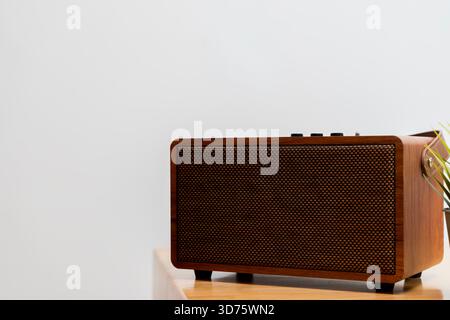 Retro-Lautsprecher aus Holz auf einem minimalistischen Tisch mit warmer Textur und moderner Funktionalität. Ideal für Wohnkultur, Audiotechnologie, Stockfoto