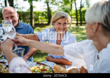Generationenübergreifende Familientoasten während einer Grillparty im Freien. Stockfoto