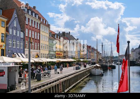 Nyhavn Uferpromenade mit farbenfrohen Häusern und verankerten Booten im lebhaften Kopenhagen, Dänemark Stockfoto