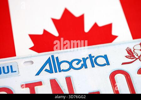 Alberta kanadisches Autokennzeichen auf der Flagge Kanadas Nahaufnahme. Führerschein- und Zulassungskonzept Stockfoto