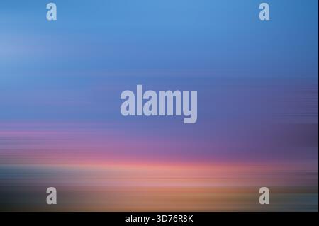 Bewegungshintergrund unschärfen, blauer violetter orangefarbener Verlauf. Magentafarbene Hintergrundbewegung bei Sonnenuntergang Stockfoto