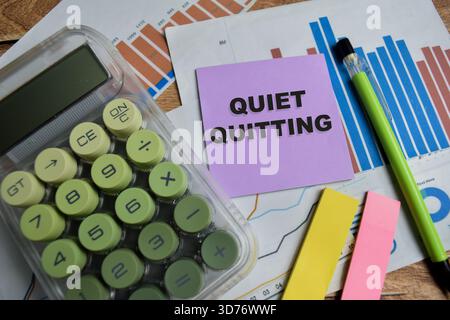 Das Konzept des leisen Beenden von Schreibtischnotizen, die auf Holztisch isoliert sind. Stockfoto