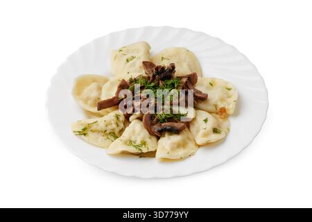 Köstliche Teigtaschen serviert mit Pilzen und Kräutern auf einem weißen Teller Stockfoto