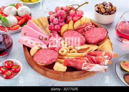 Italienische Antipasti. Wurstplatte mit Käse und anderen Snacks, mit Wein, Oliven, Burrata, Tomaten, usw. Stockfoto