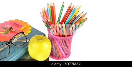 Bücher, Buntstifte, Gläser und ein grüner Apfel auf weißem Hintergrund. Freier Platz für Text. Breites Foto. Stockfoto