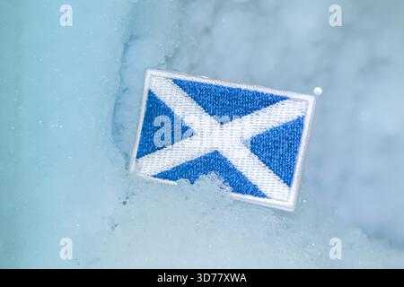 Der schottische Saltyre-Patch liegt in einem glazialen Highland-Tal und spiegelt den Wintertourismus, arktische Reisen und kulturelle Identität unter eisigen Bedingungen wider. Stockfoto