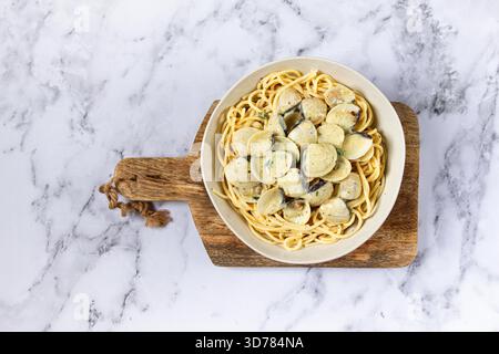 Spaghetti mit Vongole Venusmuscheln, in Sahnesauce, Carbonara, auf einem Marmortisch, hausgemacht, Draufsicht, keine Leute, Stockfoto