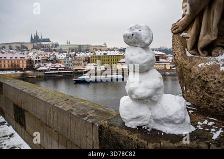Prag, Tschechische Republik. November 2025. Ein Schneemann auf der Karlsbrücke mit Prager Burg im Hintergrund, in Prag, Tschechien, am 24. November 2025. Quelle: VIT Simanek/CTK Photo/Alamy Live News Stockfoto