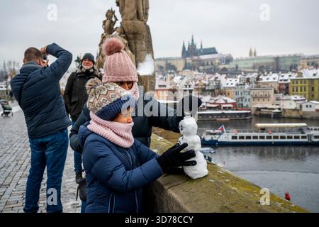 Prag, Tschechische Republik. November 2025. Ein Schneemann auf der Karlsbrücke mit Prager Burg im Hintergrund, in Prag, Tschechien, am 24. November 2025. Quelle: VIT Simanek/CTK Photo/Alamy Live News Stockfoto