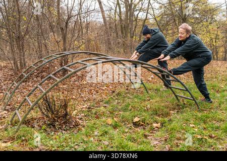 Frau, die im Freien mit Personal Trainer trainiert. Alte Frauen dehnen Sport-Workout Stockfoto