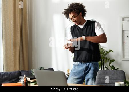 Hübscher junger Mann, der zu Hause fantasievoll wirkt, umgeben von modernem Dekor. Stockfoto