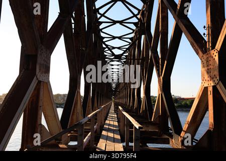Wunderschöne alte, rostige Eisenbahnbrücke bei Sonnenuntergang über dem Fluss Save in Belgrad, Serbien Stockfoto