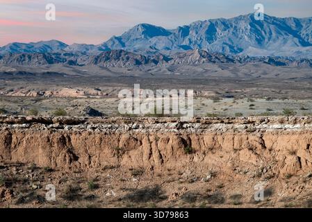 Dieses Bild wurde in der Lake Mead National Recreation Area in Nevada aufgenommen. Es bietet Berge in der Ferne, beleuchtet durch das warme Licht des Sonnenuntergangs. Stockfoto