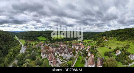 Aus der Vogelperspektive des Klosters Bebenhausen eingebettet zwischen sanften grünen Hügeln und üppigen Wäldern unter einem dramatischen, bewölkten Himmel, Bebenhausen, Baden-Württemberg, Stockfoto