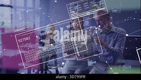 Teamkollegen bei Geschäftsbekleidung, der sich über ein Tablet stützt und im Büro einen Stift mit numerischen Codes anzeigt Stockfoto