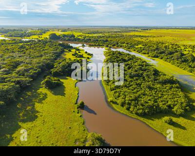 Aus der Vogelperspektive auf den Serpentinfluss schlängelt sich durch die lebendige grüne Landschaft von Reserva Natural El Encanto de Guanapalo, San Luis de Palenque, Casa Stockfoto