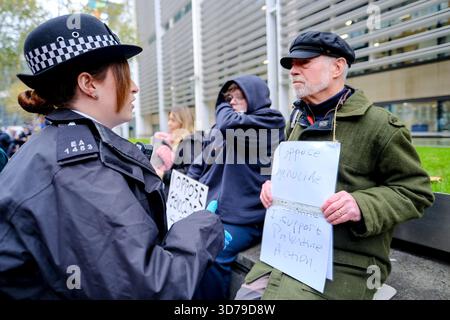 London, Großbritannien. November 2025. Anhänger, die sich für die Aufhebung der Direktaktionsgruppe Palästina-Aktion einsetzen, versammeln sich vor dem Innenministerium mit Schildern, die darauf stehen: "Ich lehne Völkermord ab/ich unterstütze die Palästinensische Aktion", und werden von wartenden Polizeibeamten verhaftet. Verteidigung unsere Geschworenen haben eine Reihe von "Aufhebung des Verbots"-Protesten vor der gerichtlichen Überprüfung gegen das Verbot organisiert, das vor dem Obersten Gerichtshof verhandelt wird. Nach dem heutigen Vorgehen wurden rund 50 Menschen in Gewahrsam genommen. Quelle: Eleventh Photography/Alamy Live News Stockfoto