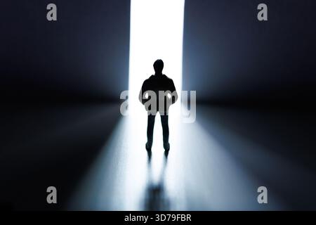 Mann, der vor einer offenen Tür steht, mit Lichtern, die durchkommen Stockfoto