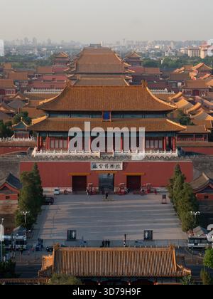 Der Blick auf die majestätische, symmetrische Architektur mit ihren orangen Dächern und roten Wänden steht in krassem Kontrast zur entfernten Skyline der Stadt, Peking, Beij Stockfoto