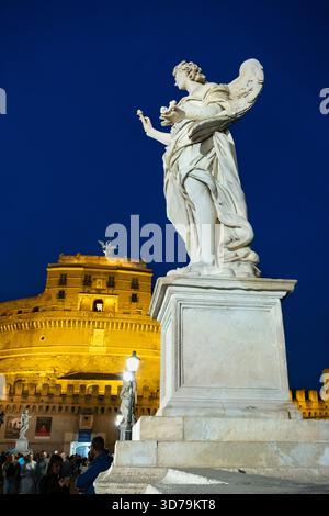 Beleuchtete Engelsstatuen in der Nacht auf der Ponte Sant'Angelo, mit der Engelsburg im Hintergrund. Rom, Italien. Stockfoto