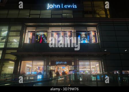 Das beleuchtete Äußere des John Lewis Kaufhauses in Liverpool ONE in der Nacht mit dem großen Neonlogo und Schaufensterpuppen. Stockfoto