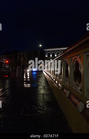 Perspektivischer Blick auf den Bürgersteig in Richtung White Hart mit Menschen in der Nacht im Stadtzentrum Stockfoto