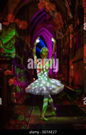 London, Großbritannien. November 2025. Die Ballerina Sophie Elizabeth funkelt in „die Engel kommen!“ Lichtshow von Luxmuralis in der Southwark Cathedral. Die Zusammenarbeit zwischen der Skulptur und dem Künstler Peter Walker und dem Komponisten David Harper bringt beeindruckende Projektionen von festlichem Licht und Klang in das Innere der Kathedrale, die am 24-26. November stattfindet. Guy Corbishley/Alamy Live New Stockfoto