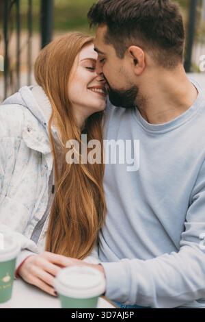 Liebende tauschen warme Herbstgefühle aus, Paare teilen zarte Momente in warmer und gemütlicher Herbstumgebung Stockfoto