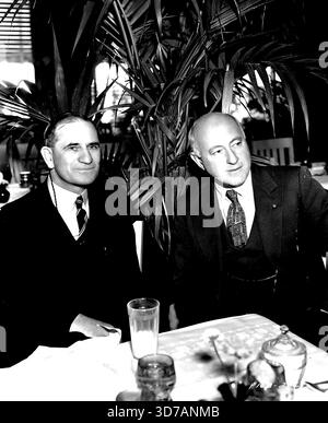 Australisch ***** Im Paramount Studio ist Hr. H. D. Drummond, Minister ***** New South Wales, der in Hollywood ist, um zu ermitteln ***** Entwicklung von Bildungsfilmen. Gezeigt mit ihm, rechts, B. DeMille, der gerade die erste Ausbildung abgeschlossen hat ***** Produziert in einem großen Studio für exklusiven Vertrieb ***** Schulen. Das Bild basiert auf DeMilles 'The Plains ***** Die Hauptrollen von Gary Cooper und Jean Arthur sind die Entwicklung der Ebenen Nordamerikas. Januar 1937. (Foto: Paramount Film Service Limited). Stockfoto
