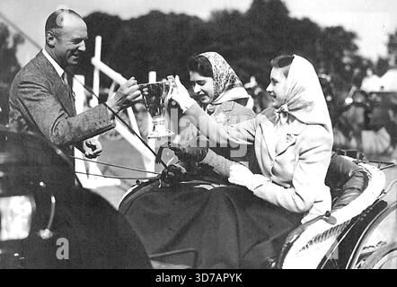Royal Horse Show im Windsor Home Park: Der Duke of Beaufort präsentiert Prinzessin Elizabeth und Margaret Rose den Silver Cup für die beste Einzelteilnahme in der privaten Fahrklasse. Mai 1945. (Foto von der Tropenpresse). Stockfoto
