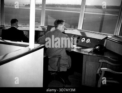 Neuer Kontrollturm am Hatfield-Flugplatz -- Ein neuer Kontrollturm ist jetzt am Hatfield-Flugplatz, dem Hauptquartier de Havilland, in Betrieb, mit aktueller Ausrüstung, die das Allwetter-Fliegen erleichtern wird. In das Design dieses Turms sind viele moderne Neuerungen integriert, die den neuesten Kenntnissen und Praktiken entsprechen und für die absehbare Zukunft geeignet sind. Das Innere des Schaltzentrums, 80 m. Über dem Asphalt, im neuen Turm am Hatfield Flugplatz mit zwei Männern im Dienst. August 1954. (Foto von Fox Photos). Stockfoto