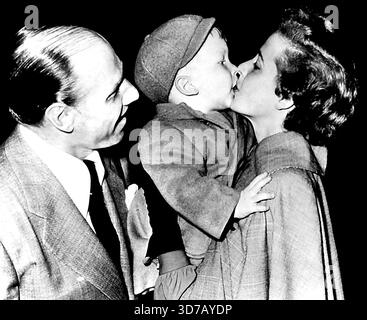 Leo und Laraine, auf dem Weg zum Frühjahrstraining - Laraine Day gibt ihrem Adoptivsohn Christopher 2 einen Abschiedskuss, während die Schauspielerin und ihr Mann, Leo Durocher, heute Abend mit dem Flugzeug nach New York gefahren sind, Durocher, der letzte Woche zum zweiten Mal Miss Day geheiratet hat, zustimmend zusieht. Er ist nächste Woche im Frühjahrstraining-Camp der Brooklyn Dodgers in Santa Domingo. Februar 1948. (Foto von AP Wirephoto) Stockfoto