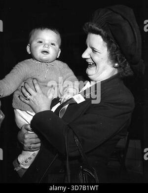 Haven in Maryland -- Mrs. August Klecka, einziges weibliches Mitglied des Maryland State Committee for the Resettlement of Displaced Parsons, bestrahlt mit Zustimmung des siebenmonatigen Wasyl Kornylo, der zu einem guten amerikanischen Bürger aufwachsen wird. Februar 1949. (Foto von ACME). Stockfoto