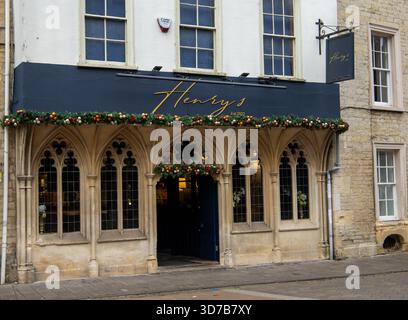Traditionelles, weihnachtlich dekoriertes Steingebäude mit Bogenfenstern und Restaurant namens Henry's Cirencester Gloucestershire UK Stockfoto