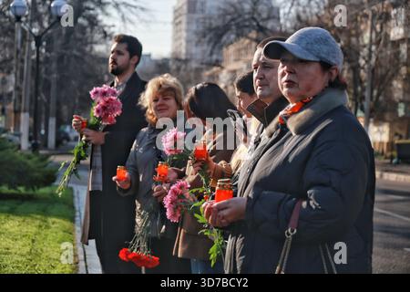 Die Bewohner halten Blumen im Rahmen einer Zeremonie zu Ehren der Opfer des Holodomors 1932–1933 und der künstlichen Hungersnöte von 1921–1923 und 1946–1947 im Holodomor-Denkmal in Odesa, Ukraine, am 22. November 2025 (Foto: Nina Liashonok/Ukrinform) Stockfoto