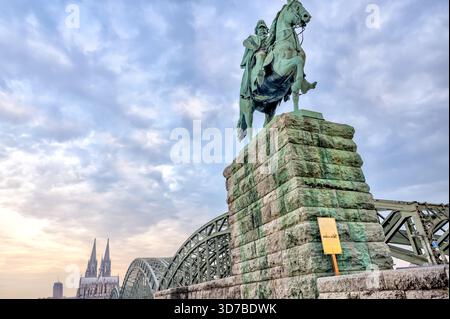 Die Reiterstatue Kaiser Wilhelm I. am östlichen Ende der Hohenzollernbrücke bei Sonnenaufgang in Köln Stockfoto